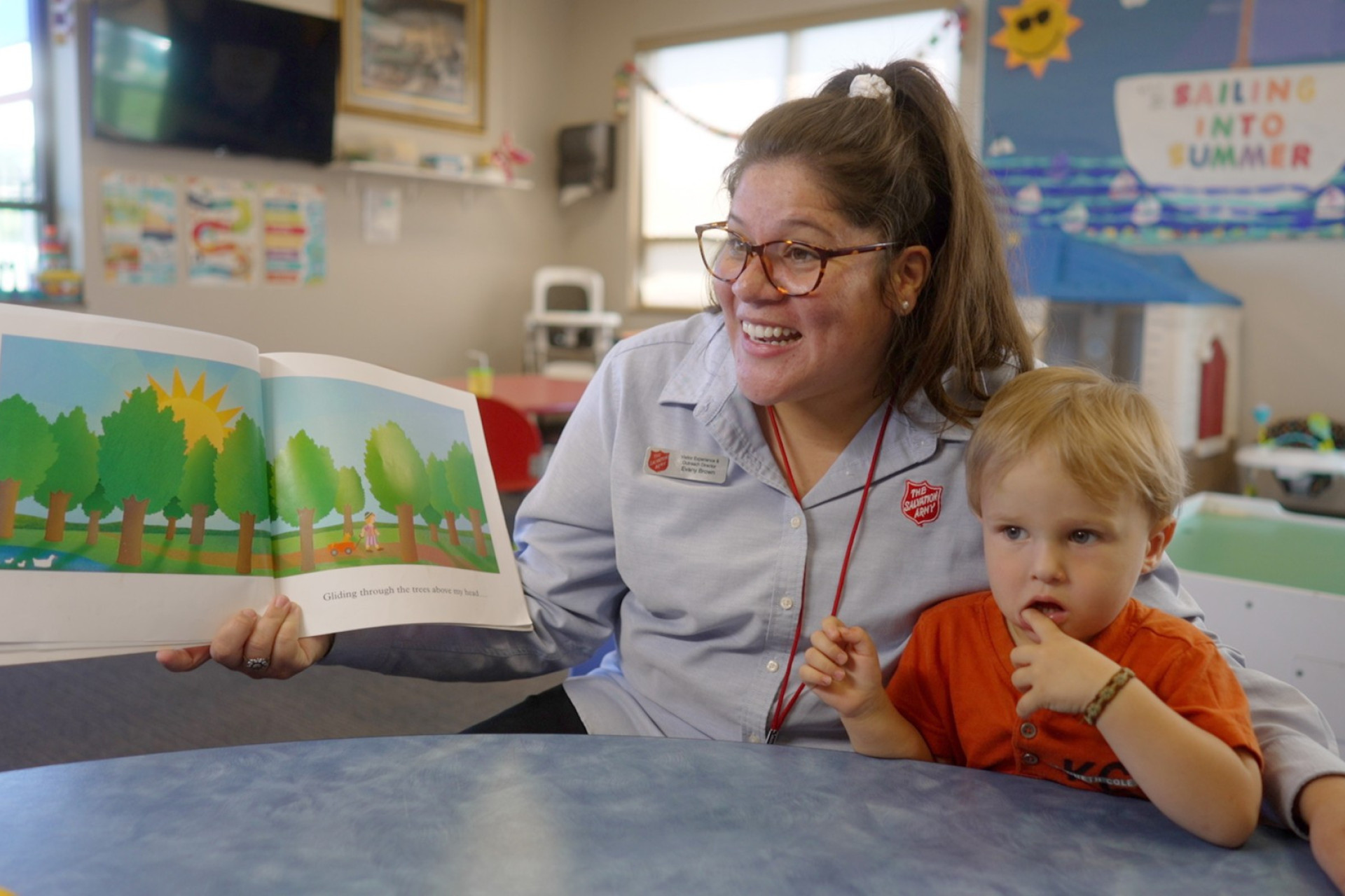 Salvation Army volunteer reading a book to kids